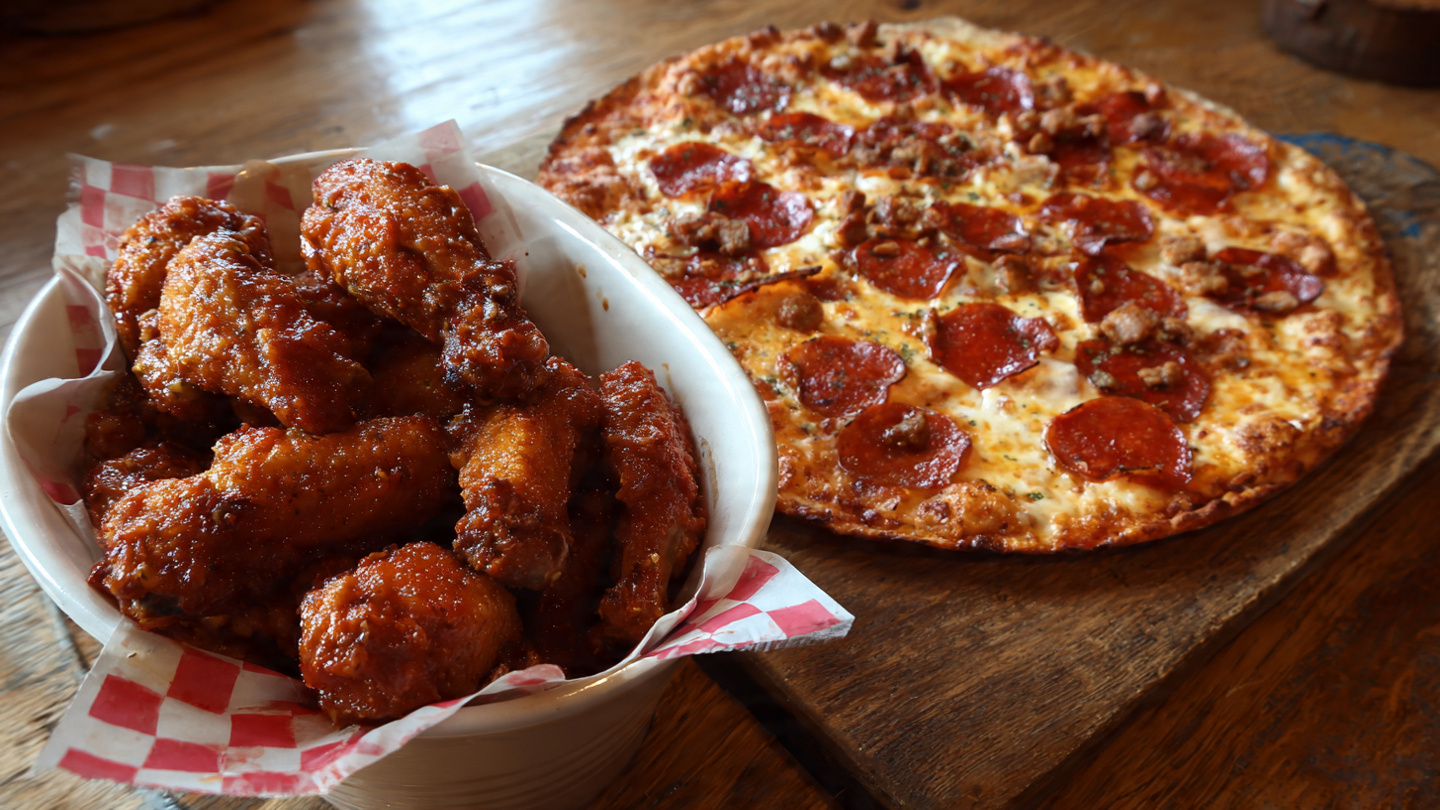 Large pepperoni pizza with crispy chicken wings